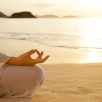 woman meditating at sunset on the Caribbean beach